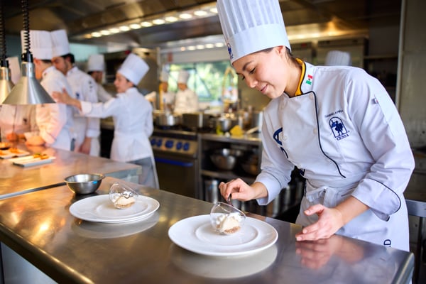 Estudiantes de Gastronomía de CESSA preparando un postre