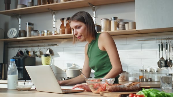 Mujer en cocina con computadora