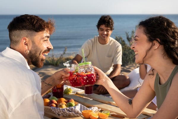 Amigos con bebidas en playa
