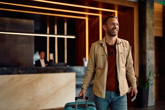 un-invitado-feliz-del-hotel-con-una-bolsa-de-viaje-caminando-por-el-vestibulo