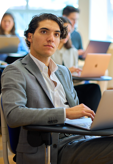 Alumno de CESSA Universidad en salón de clases con laptop